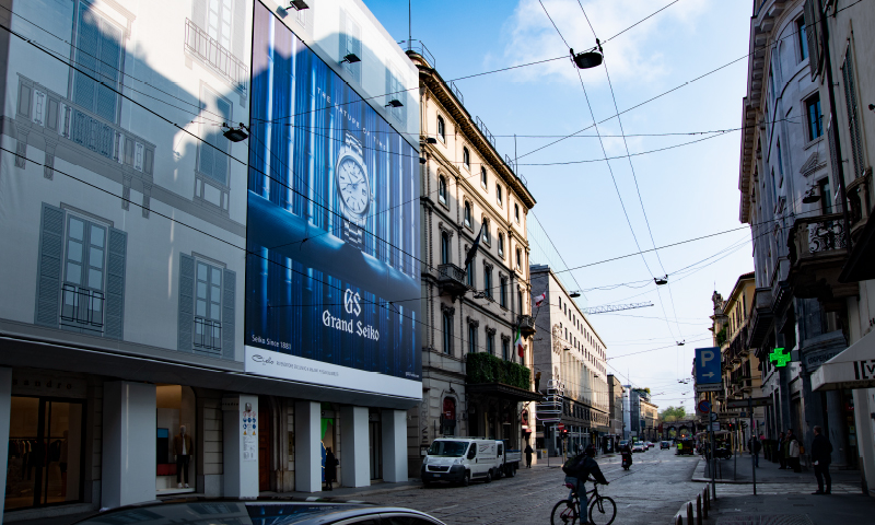 Photo of a large billboard installed alongside the boulevard where there are many luxury brand stores.