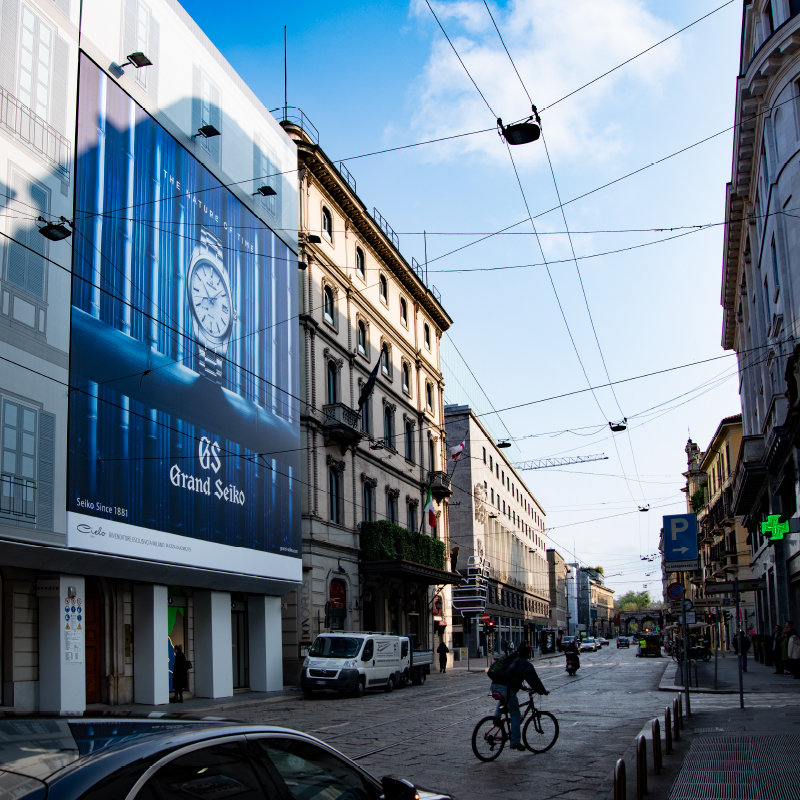 Photo of a large billboard installed alongside the boulevard where there are many luxury brand stores.