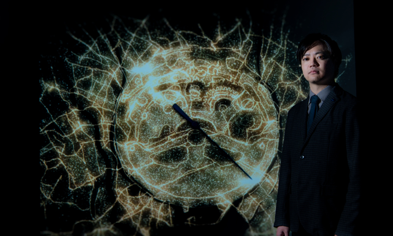 Photo of Yoshida standing in front of the special film piece “movement”
