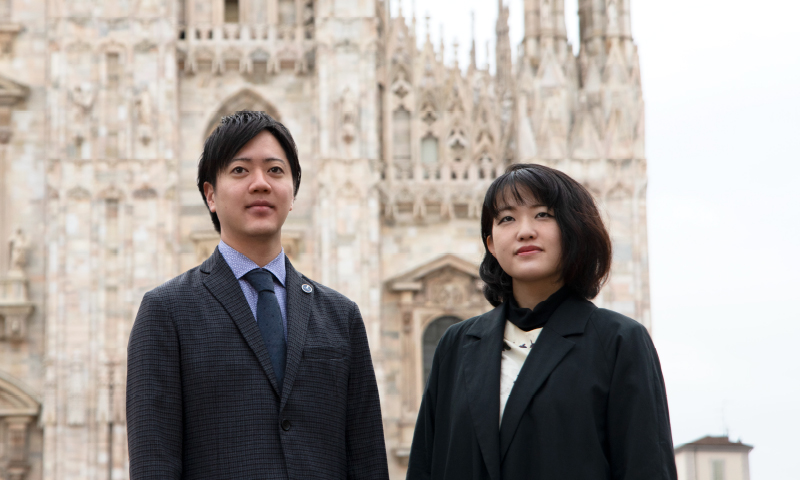 Yoshida and Koriyama standing in the Piaza del Duomo in front of the Milan Cathedral