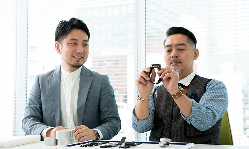 時計を見つめる文殊川と岸野の写真