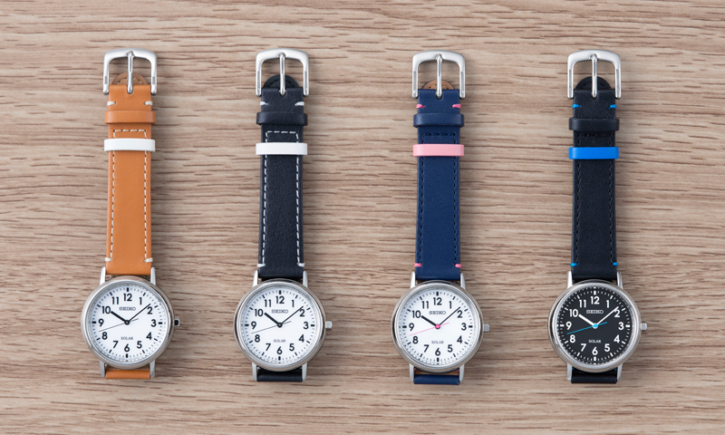 Photo of the four different Seiko School Time models. (STPX069) with white dial and camel strap / (STPX073) with white dial and black strap / (STPX071) with white dial, navy blue + pink strap / (STPX075) with black dial and black + blue strap