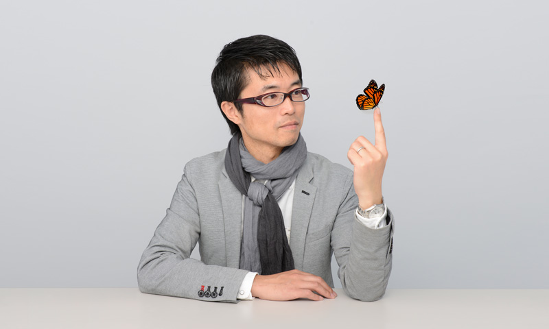 Photo of Kubo with a butterfly on his fingertip