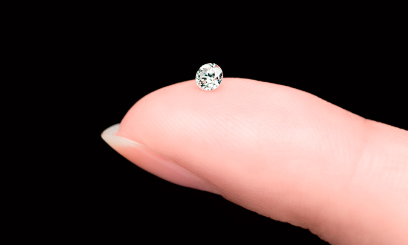 Photo of a single diamond on a fingertip