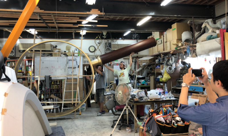 Photo of a huge magnifying glass in the middle of production. The diameter of the lens part is larger than the staff.