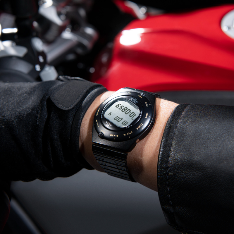 Photo of Speedmaster on the left hand gripping the handlebar of a motorcycle