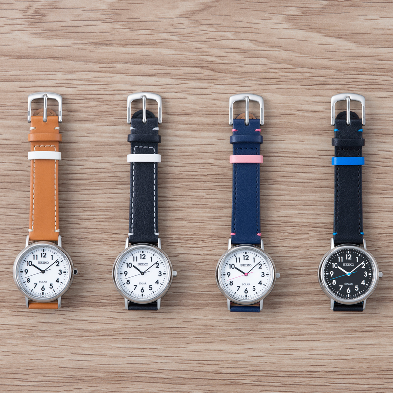 Photo of the four different Seiko School Time models. (STPX069) with white dial and camel strap / (STPX073) with white dial and black strap / (STPX071) with white dial, navy blue + pink strap / (STPX075) with black dial and black + blue strap