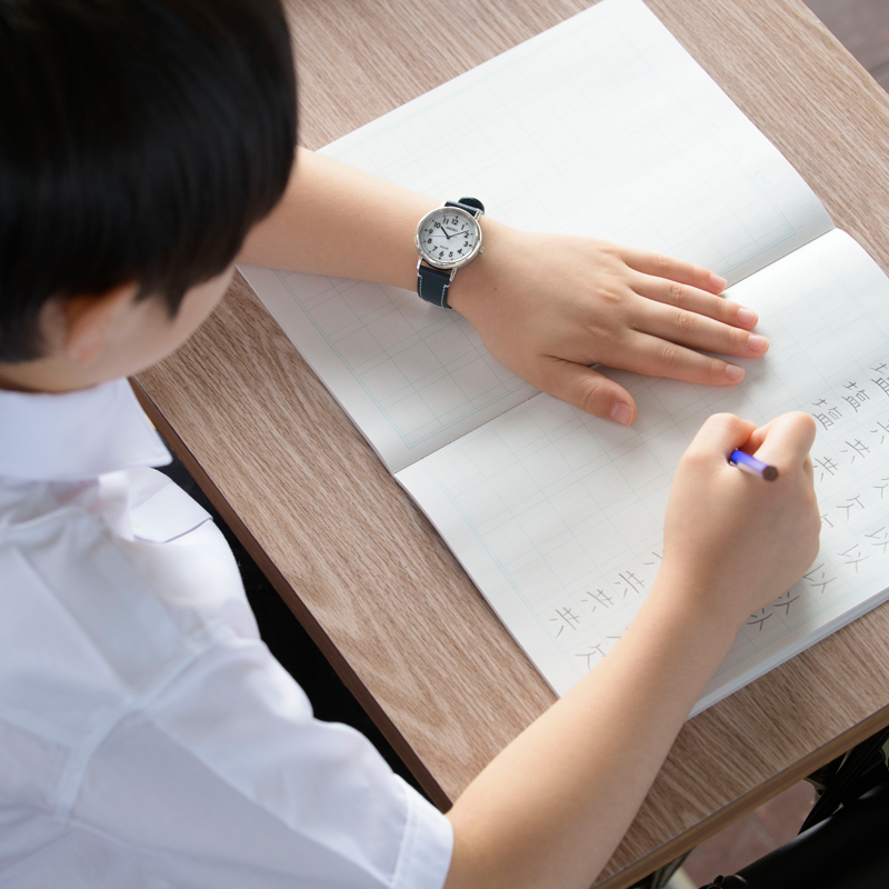Photo of an elementary school student practicing kanji with the Seiko School Time watch