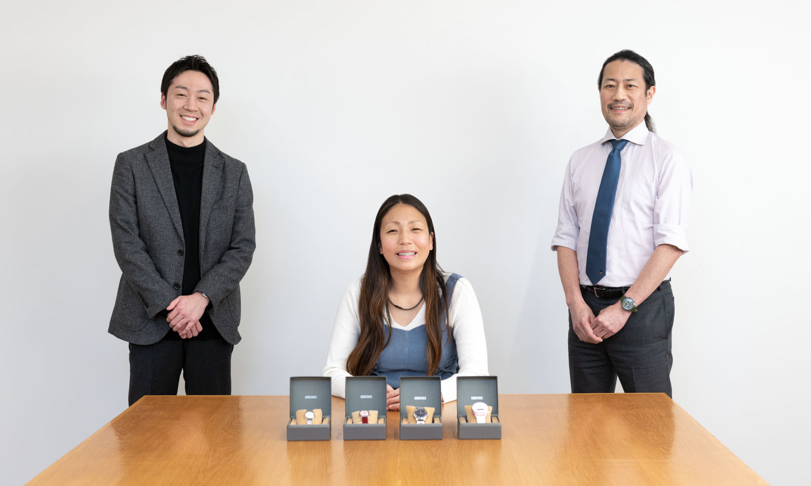 Photo of Mr. Matsue (left), Ms. Takada (center), and Mr. Hasegawa with barrier-free watches.