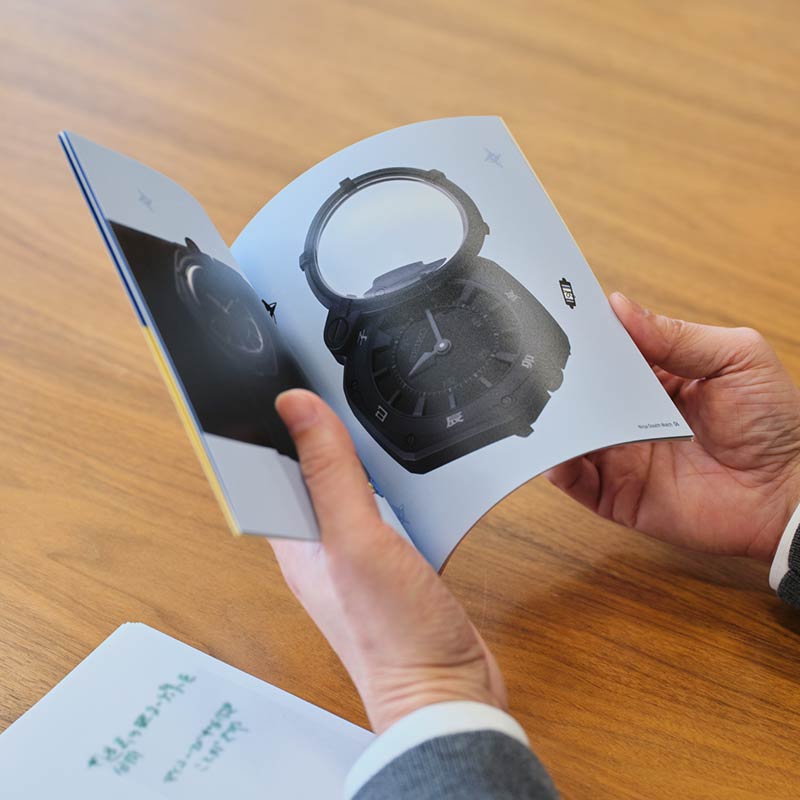 小冊子の「忍者専用腕時計」ページを見る写真